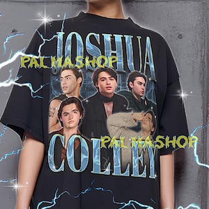 May include: Black oversized t-shirt featuring a graphic of multiple people with the text "JOSHUA COLLEY" and "PALMASHOP" in a blue and white design. The shirt has a crew neck and short sleeves.