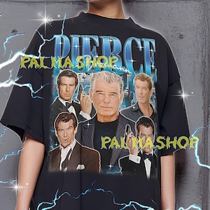 Może przedstawiać: Czarny, duży t-shirt z kolażem zdjęć Pierce'a Brosnana. Koszulka ma napis "PIERCE" w kolorze niebieskim i "PALMA SHOP" w kolorze żółtym. Modelka ma na sobie koszulkę w rozmiarze XL.