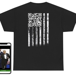 May include: Black t-shirt with a distressed white American flag design and a QR code. The shirt is shown with a smartphone displaying a video.
