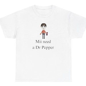 May include: White t-shirt with a cartoon Mii character holding a Dr Pepper can. The text "Mii need a Dr Pepper" is printed below the character.