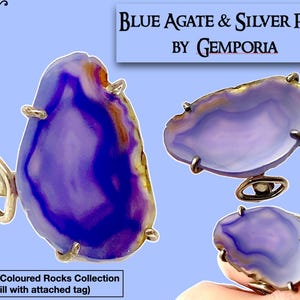 May include: A blue agate and silver ring from the Coloured Rocks Collection by Gemporia. The ring features a large, irregularly shaped blue agate stone with purple and white swirls.