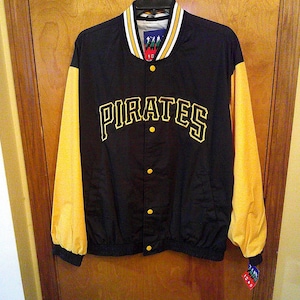 May include: Black and gold Pirates baseball jacket. The jacket has gold sleeves and the word "PIRATES" in gold lettering across the chest. The jacket has a black body with gold buttons and trim. The collar is white with gold and black stripes.