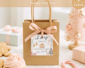 May include: A brown paper gift bag with two handles and a light pink ribbon tied in a bow. A square tag is attached to the ribbon featuring a gingerbread house, holiday icons, and the text: oh snap THANK YOU FOR JOINING MY PARTY Love Sarah.