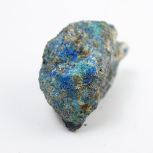 May include: A rough, blue and green mineral specimen with a mottled, uneven surface.