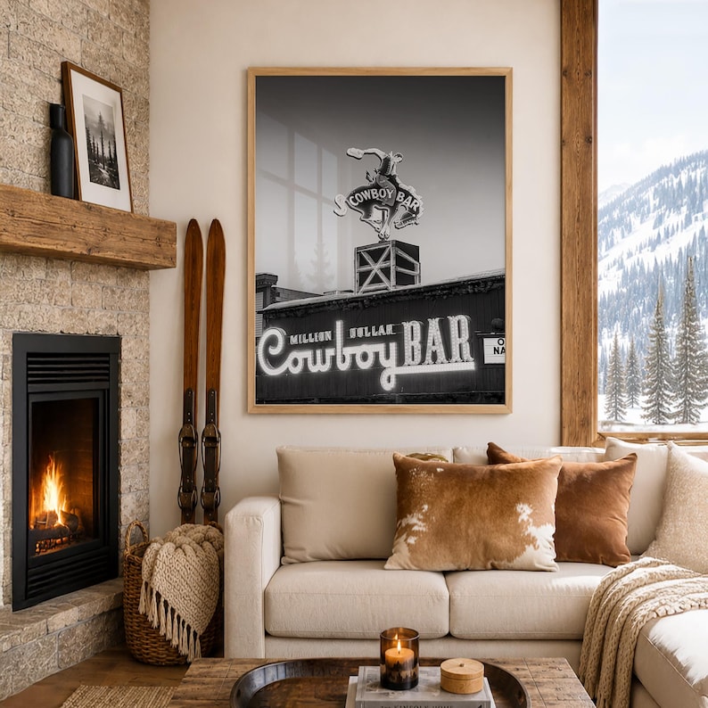 May include: A black and white framed wall art print featuring the Million Dollar Cowboy Bar sign with a bucking horse silhouette. The rectangular print is displayed in a light wood frame, showcasing the iconic neon signage and architectural details.