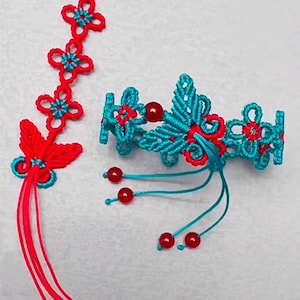 Op de afbeelding: Twee handgeknoopte armbanden met rode en turquoise draad. De ene armband is een lange streng met een kwast en de andere is een ronde armband met een vlinderontwerp. Beide armbanden hebben rode kralen.