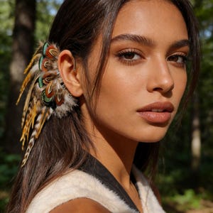 Può includere: Un ear cuff di piume colorate con piume marroni, verdi, gialle e arancioni. L'ear cuff è attaccato all'orecchio con un piccolo cerchio d'argento. La persona indossa un gilet bianco e nero.