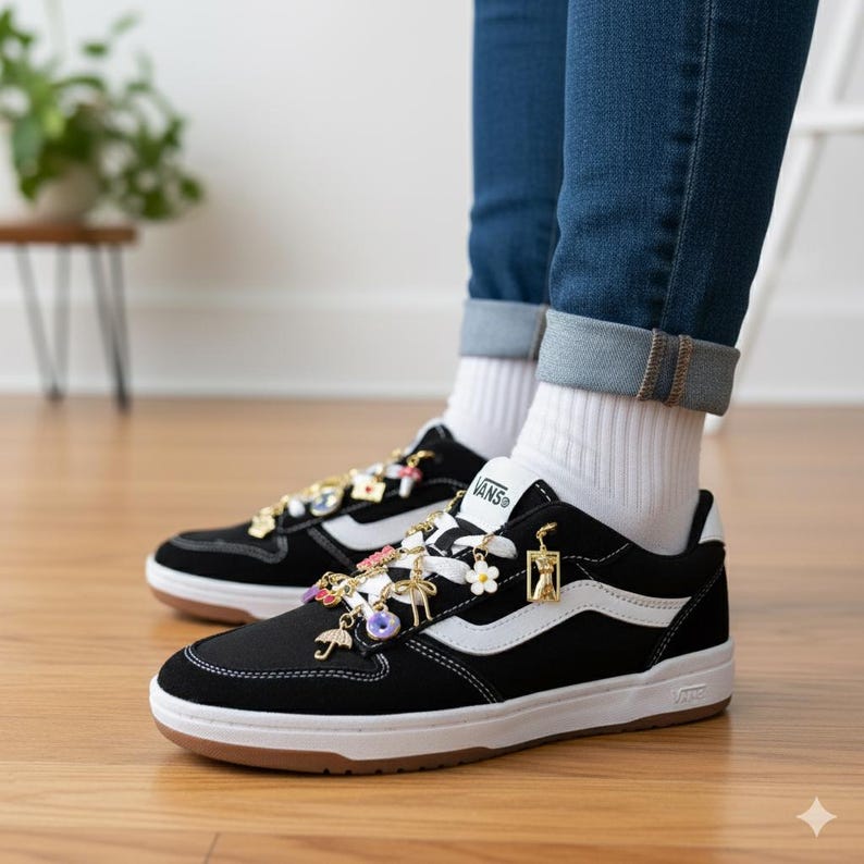 Puede incluir: Zapatillas Vans negras con rayas laterales y suelas blancas. Las zapatillas est&aacute;n adornadas con abalorios decorativos de varias formas y colores, incluyendo flores, paraguas y palmeras. Los zapatos se llevan con calcetines blancos y vaqueros azules.