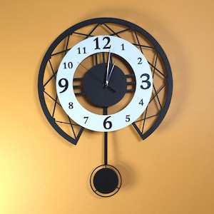 May include: A contemporary wall clock with a black geometric frame and a white clock face. The clock face has black numerals and hands, with a black centre and a pendulum. The clock is mounted on a yellow wall.