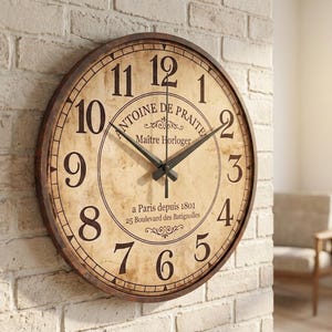 Peut inclure: Une horloge murale ronde avec un cadre brun foncé et un cadran beige effet parchemin. Elle présente des chiffres arabes noirs, des aiguilles noires et le texte Antoine de Praite, Maître Horloger, a Paris depuis 1801, 25 Boulevard des Batignolles.