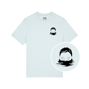 Könnte beinhalten: Hellblaues T-Shirt mit schwarzer Grafik eines Gesichts, das aus dem Wasser auftaucht. Auf dem oberen Rücken steht der Text "mah". Eine kreisförmige Grafik des gleichen Designs befindet sich unten rechts.