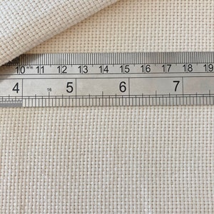 Puede incluir: Primer plano de una tela blanca con una regla que mide 17,8 cm. La tela tiene un patr&oacute;n de cuadr&iacute;cula.