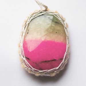 May include: A pink, green, and white agate gemstone pendant wrapped in white thread with a white tassel.