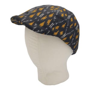 May include: A black and yellow patterned cotton newsboy cap. The cap has a flat top and a curved brim.