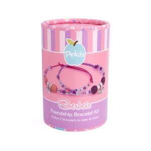 Puede incluir: Kit de pulseras de amistad Sherbets de Pipkits, rosa y morado. El kit incluye cuentas, cuerda y dijes para hacer dos pulseras. El empaque presenta un dise&ntilde;o a rayas rosa y morado con un logotipo de manzana blanca y el texto "Pipkits" y "Sherbets Friendship Bracelet Kit".