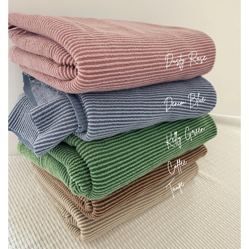 A stack of four folded, ribbed knit fabrics in dusty rose, denim blue, kelly green, and coffee, with their color names printed next to them.