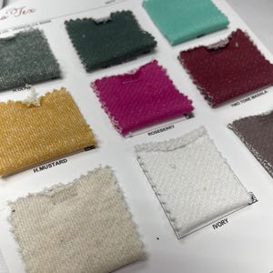 Fabric swatch card displaying small square samples of French terry fabric with printed color names.