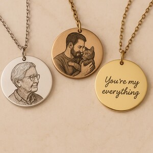 May include: Three personalized pendant necklaces. One silver-toned pendant features a portrait of a person wearing glasses. A gold-toned pendant shows a man holding a cat. The third gold-toned pendant has the text "You're my everything."