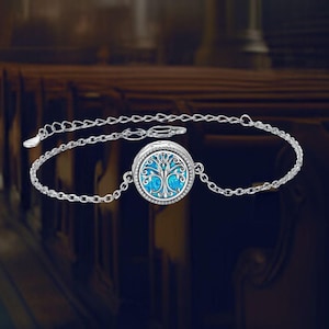 May include: A silver chain bracelet with a round pendant featuring a blue tree of life design.