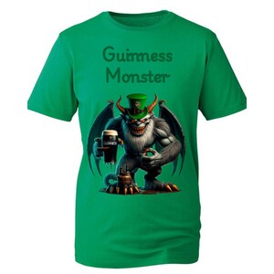 May include: Green t-shirt with a white monster holding a glass of Guinness beer. The monster is wearing a green hat with a shamrock on it. The text "Guinness Monster" is printed on the shirt.