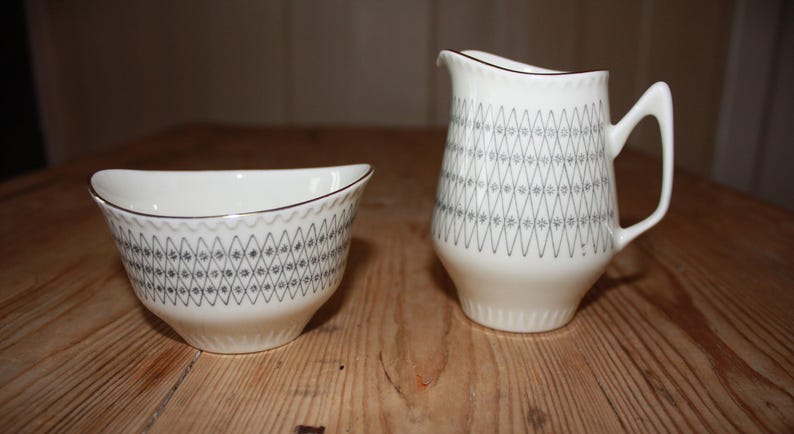 May include: A set of three ceramic nesting bowls in shades of blue, green, and white. The bowls feature a speckled glaze and a simple, modern design. The largest bowl is approximately 7 inches in diameter.