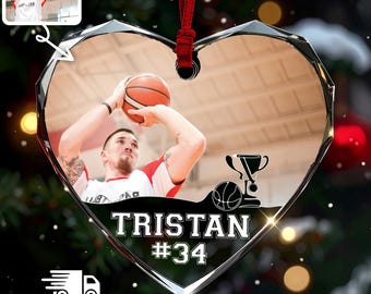May include: A heart-shaped acrylic ornament featuring a printed photograph of a basketball player holding a ball above their head. The design includes a trophy icon, a basketball graphic, and the text TRISTAN #34, suspended by a red ribbon.