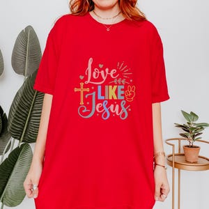 May include: Red t-shirt with a colorful graphic that says "Love Like Jesus" with a peace sign and a cross.