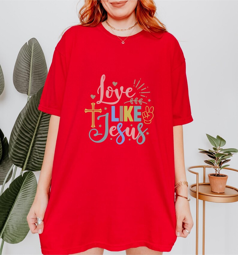 May include: Red t-shirt with a colorful graphic that says "Love Like Jesus" with a peace sign and a cross.