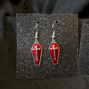 Red coffin-shaped dangle earrings with cross
