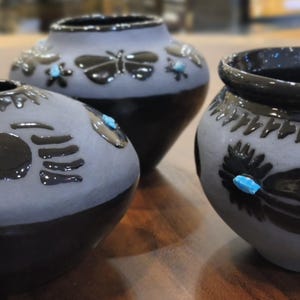 Inheemse handgemaakte vaas van zwart aardewerk: Doornroosje turkoois - 3 opties: vlinder, veer, berenpoot