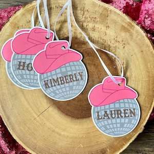 May include: Three silver disco ball ornaments with pink cowboy hats and personalized names: Holly, Kimberly, and Lauren.