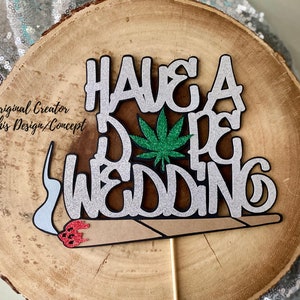 May include: A silver glitter cake topper with the text "Have a Dope Wedding" and a green marijuana leaf. A brown and white marijuana joint is attached to the bottom of the topper.