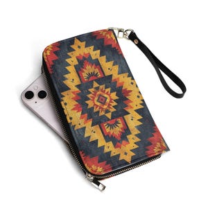 May include: A black leather wallet with a zip fastening and a detachable wrist strap. The wallet features a colourful geometric pattern in shades of red, yellow, and blue.