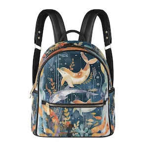 Peut inclure: Un sac à dos bleu avec un imprimé coloré de dauphins et de vie marine. Le sac à dos a des bretelles noires et une fermeture à glissière.