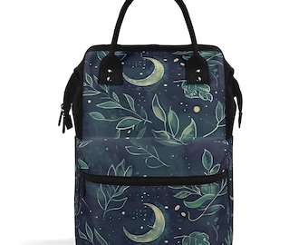May include: A dark blue and green backpack with a crescent moon and floral pattern. The backpack has a black zipper and a black handle.