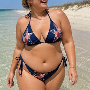 May include: A navy blue bikini set featuring a red, white, and blue star pattern on the cups and the bottom. The bikini top has triangle cups with tie straps, and the bikini bottom features side tie closures with a matching star design.