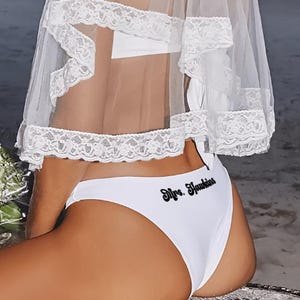 Braguita de bikini con escote en V y etiqueta con la letra inicial de la señora. Braguita de bikini de novia.
