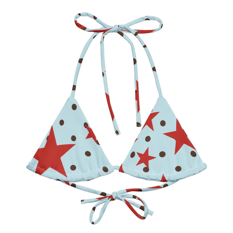 May include: A light blue bikini top with a red star and brown polka dot pattern. The top has tie straps at the neck and back. This swimwear is perfect for a summer day at the beach or pool.