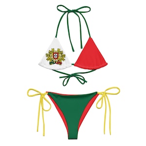 Könnte beinhalten: Ein zweiteiliges Bikini-Set mit portugiesischem Flaggen-Design. Das Oberteil hat ein weißes Dreieck mit Wappen und ein rotes Dreieck. Das Unterteil ist grün mit rotem Futter und gelben Bindebändern.