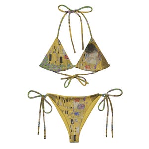 Könnte beinhalten: Ein gelber Bikini mit einem Druck von Gustav Klimts Gemälde Der Kuss. Das Oberteil ist im Dreieckstil mit verstellbaren Trägern und das Unterteil ist im frechen Stil mit Bändern an den Seiten.