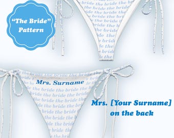 May include: White bikini bottoms with blue text that reads "the bride" and "Mrs. [Your Surname] on the back". The bikini bottoms have tie closures and a blue and white pattern. A blue circle reads "The Bride" Pattern.