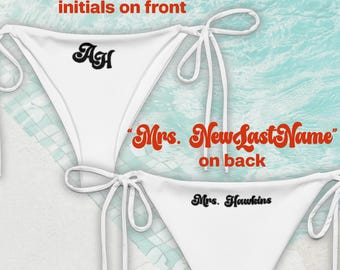 May include: White bikini bottoms with tie sides. The front features the initials "AH" in black, with the text "Curvy Script initials on front" in red. The back displays "Mrs. NewLastName" and "Mrs. Hawkins" in black.