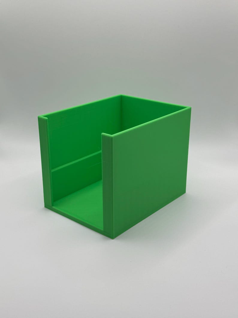 May include: A bright green, rectangular storage container with a simple, open design. The container is made of a solid material and has a smooth, matte finish. The sides are straight and the corners are sharp.