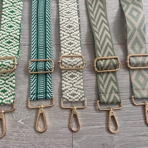 May include: Five different green and white patterned fabric straps with gold metal clasps. The straps are all the same length and width.
