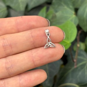 May include: Silver Celtic knot pendant charm. The pendant is a traditional Celtic knot design with three interlocked loops. It is a popular symbol of love, friendship, and eternity.