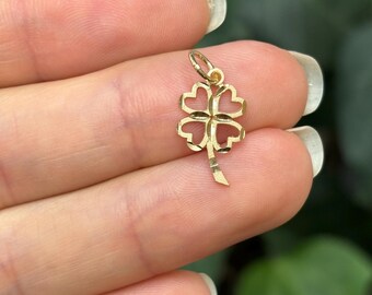 May include: A gold four-leaf clover charm pendant with a textured stem.