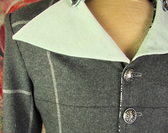 May include: A gray wool jacket with a plaid pattern and a light green collar and lapel. The jacket has silver buttons and a tailored fit. The collar and lapel are lined with light green fabric. The jacket is a classic style.