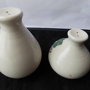 Peut inclure: Deux sali&egrave;res et poivri&egrave;res en c&eacute;ramique blanc cass&eacute;. Les sali&egrave;res ont un corps bulbeux et un petit dessus arrondi avec deux trous. L'une des sali&egrave;res pr&eacute;sente un motif floral. Ensemble assorti.