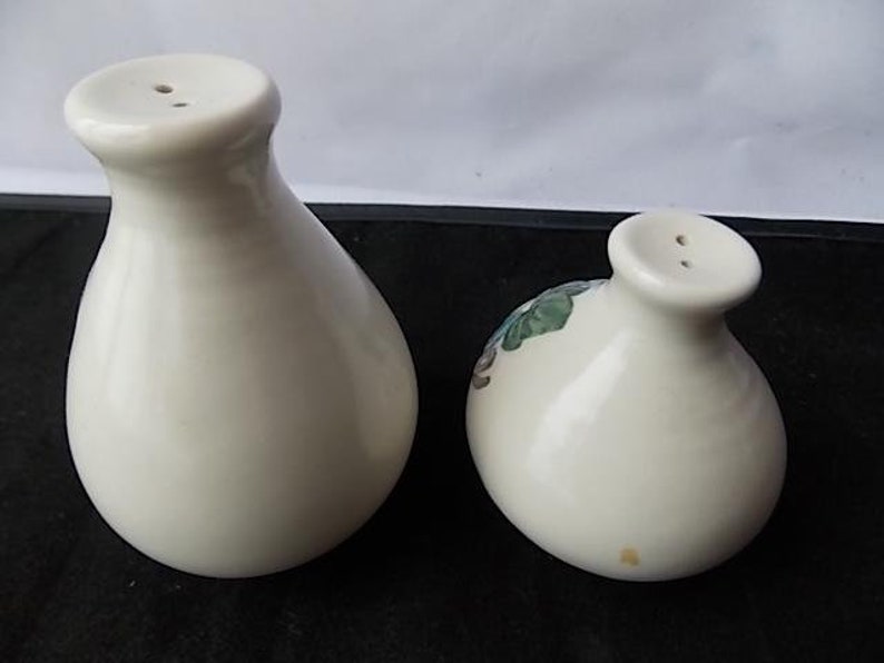 Peut inclure: Deux sali&egrave;res et poivri&egrave;res en c&eacute;ramique blanc cass&eacute;. Les sali&egrave;res ont un corps bulbeux et un petit dessus arrondi avec deux trous. L'une des sali&egrave;res pr&eacute;sente un motif floral. Ensemble assorti.