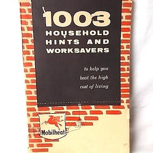 Może przedstawiać: Vintage broszura zatytułowana "1003 Household Hints and Worksavors" z obramowaniem przypominającym cegłę. Okładka zawiera biały tekst i logo Mobilheat. Broszura ma na celu pom&oacute;c czytelnikom "pokonać wysokie koszty utrzymania".